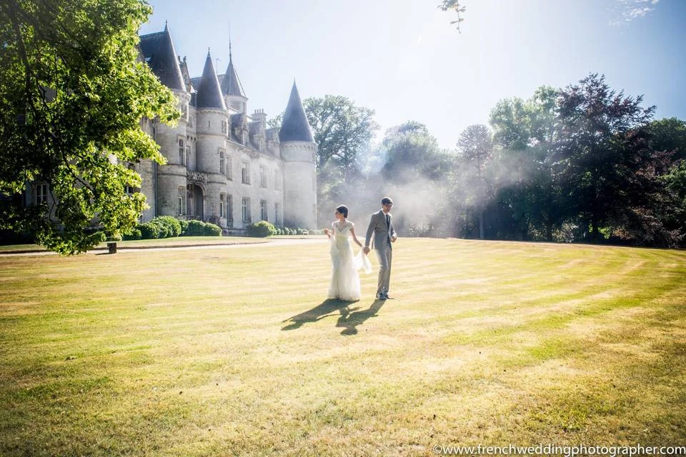 Couple de mariés devant un château, photographie issue de la galerie Jebooktoo sur Mariages.net